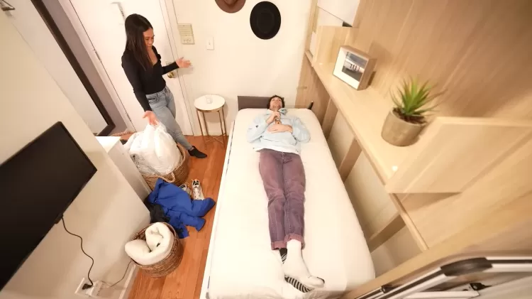 Caleb deita na cama retrátil de Nikki no microapê de Nova York Imagem: Reprodução/ YouTube/ Canal CALEB SIMPSON